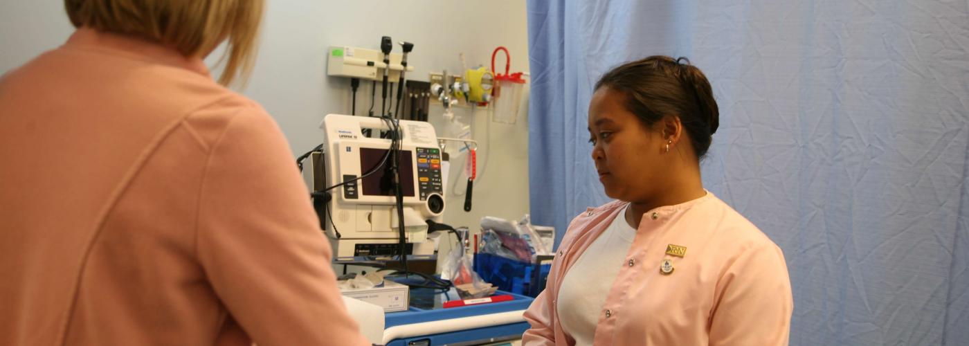 Nurses attending to patient on bed